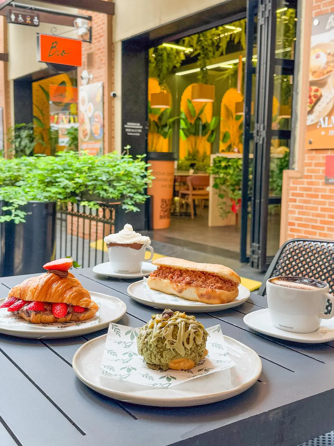 Mesa ao ar livre com croissant, café e doces